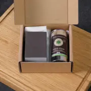 Geöffnete Verpackung des Pflege-Sets No. 4 mit OLI-NATURA Leinöl-Firnis und Zubehör im Karton