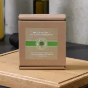 Geschlossene Originalverpackung des OLI-NATURA Pflege-Sets No. 4 auf einem geölten Schneidebrett platziert