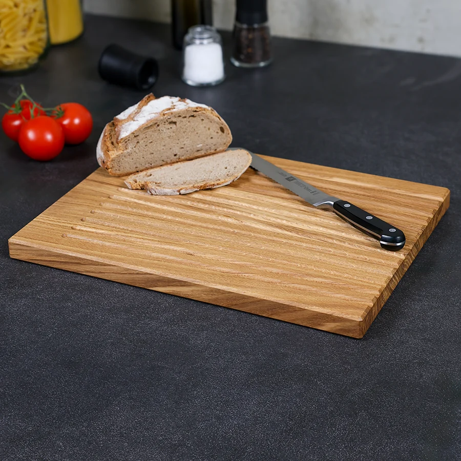 schneidebrett-brot-eiche-handgefertigt-2 Brotschneidebrett aus massivem Eichenholz mit Brot und Messer, Seitenansicht