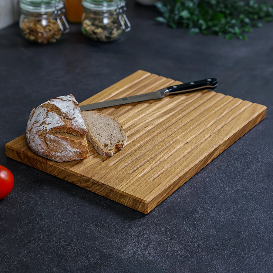 schneidebrett-brot-eiche-handgefertigt-3 Brotschneidebrett aus Eiche mit Krümelmulden, Brotlaib und Messer auf der Arbeitsfläche