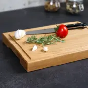 Handgefertigtes Schneidebrett aus geölter Eiche, dekoriert mit Küchenutensilien - inkl. Griffmulde und Saftrille