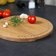 Rundes Schneidebrett aus massiver Eiche mit Saftrille und Griffmulde, handgefertigt und geölt