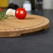 Detailaufnahme der Griffmulde eines runden Schneidebrettes aus Eichenholz, fein geschliffen und hochwertig verarbeitet